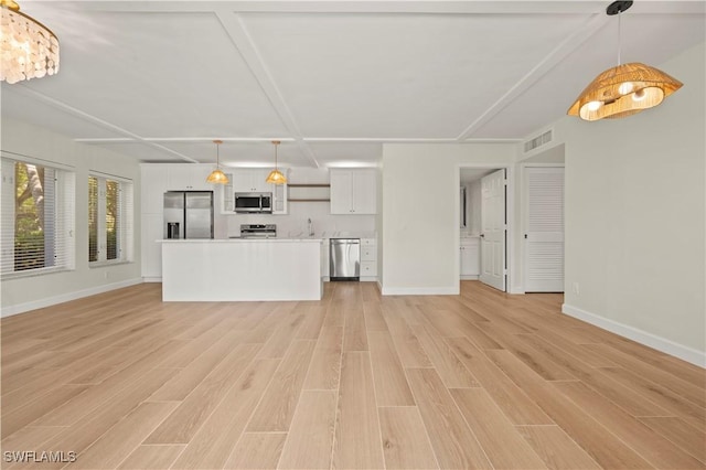 280 4th St S Unit 104, Naples, FL 34102 - unfurnished living room with light wood finished floors, a sink, and baseboards