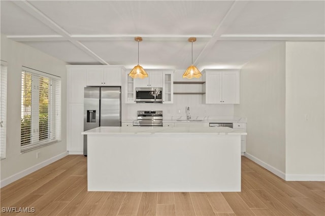 280 4th St S Unit 104, Naples, FL 34102 - kitchen with appliances with stainless steel finishes, a sink, light countertops, white cabinets, and light wood-style flooring