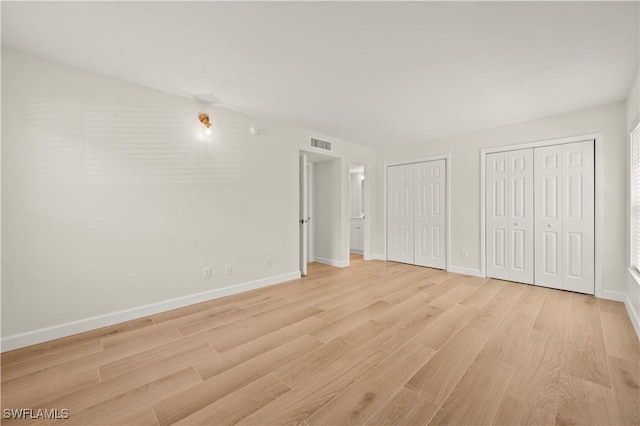 280 4th St S Unit 104, Naples, FL 34102 - unfurnished bedroom featuring multiple closets, light wood finished floors, and baseboards