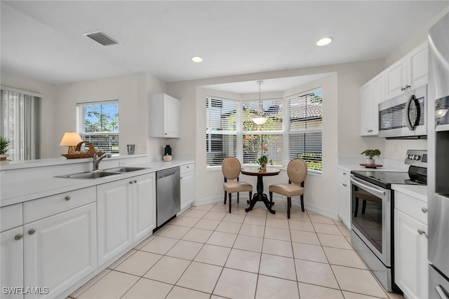 600 Diamond Cir Unit 607, Naples, FL 34110 - kitchen featuring stainless steel appliances, a sink, light countertops, white cabinetry, and recessed lighting