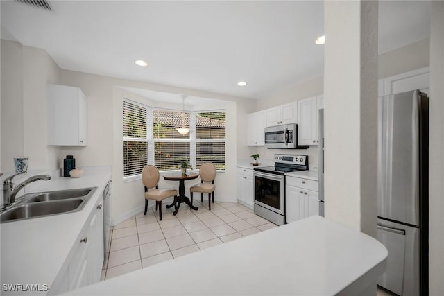 600 Diamond Cir Unit 607, Naples, FL 34110 - kitchen with stainless steel appliances, a sink, light tile patterned floors, baseboards, and light countertops