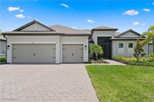 20467 Napa Loop, Estero, FL 33928 - view of front of property with decorative driveway, an attached garage, stucco siding, and a front yard