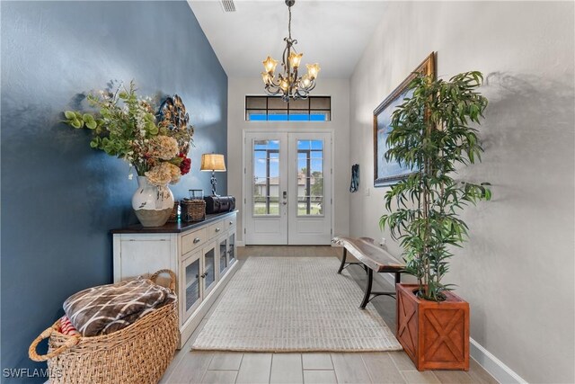20467 Napa Loop, Estero, FL 33928 - entrance foyer with french doors, a chandelier, a towering ceiling, wood finished floors, and baseboards