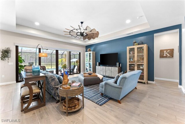 20467 Napa Loop, Estero, FL 33928 - living area with a tray ceiling, baseboards, recessed lighting, and light wood-style flooring