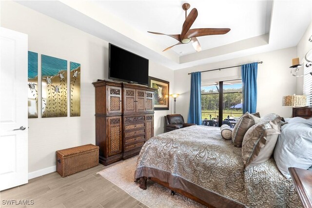 20467 Napa Loop, Estero, FL 33928 - bedroom with a tray ceiling, wood finished floors, baseboards, ceiling fan, and access to exterior