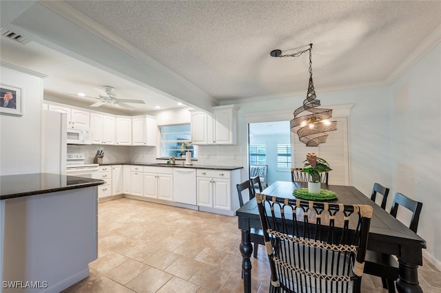 3586 Santiago Way, Naples, FL 34105 - kitchen featuring white appliances, dark countertops, crown molding, backsplash, and white cabinets