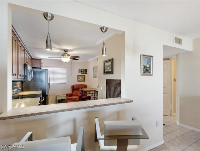 11921 Seabreeze Cove Ln Unit 104, Fort Myers, FL 33908 - kitchen with stainless steel appliances, ceiling fan, pendant lighting, light tile patterned flooring, and a breakfast bar area