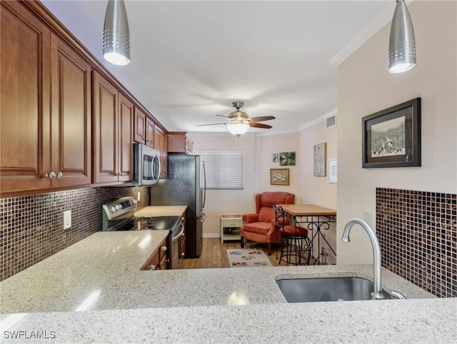 11921 Seabreeze Cove Ln Unit 104, Fort Myers, FL 33908 - kitchen with appliances with stainless steel finishes, a sink, ornamental molding, backsplash, and ceiling fan