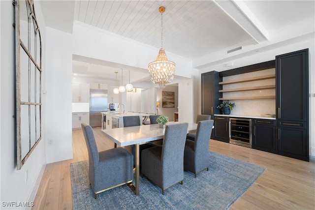 875 6th Ave S Unit 304, Naples, FL 34102 - dining area with beverage cooler, a chandelier, light wood-type flooring, beam ceiling, and wood ceiling