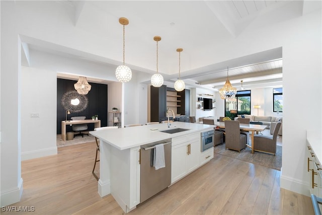 875 6th Ave S Unit 304, Naples, FL 34102 - kitchen featuring stainless steel dishwasher, a sink, a chandelier, light wood finished floors, and a kitchen island with sink