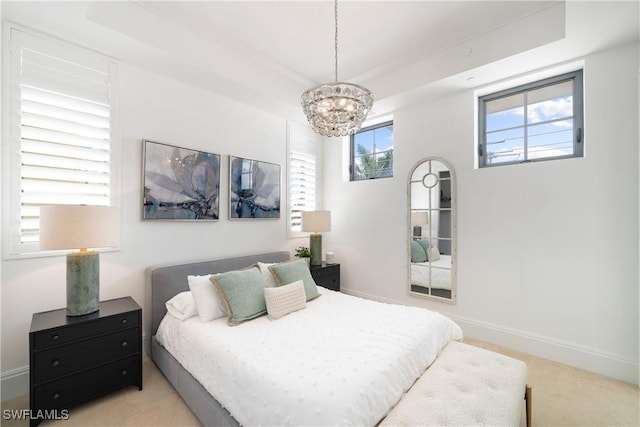875 6th Ave S Unit 304, Naples, FL 34102 - carpeted bedroom with a chandelier, a tray ceiling, and baseboards