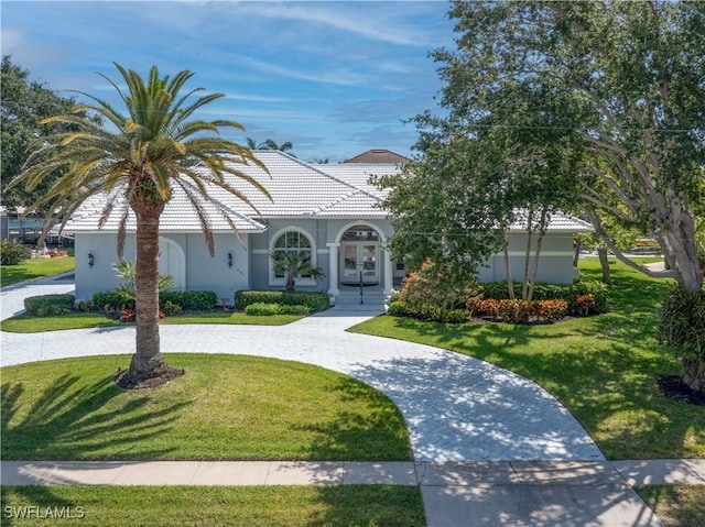 561 Conover Ct, Marco Island, FL 34145 - view of front of property featuring a front lawn, curved driveway, and french doors