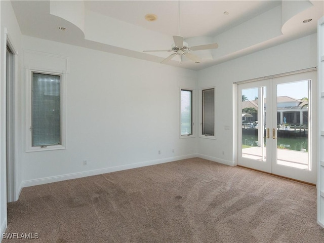 561 Conover Ct, Marco Island, FL 34145 - unfurnished room with carpet flooring, a ceiling fan, baseboards, french doors, and a raised ceiling