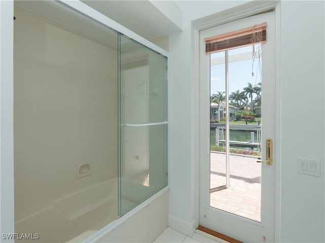 561 Conover Ct, Marco Island, FL 34145 - bathroom with combined bath / shower with glass door, a water view, and baseboards