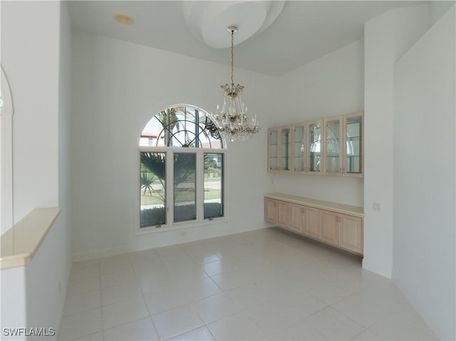 561 Conover Ct, Marco Island, FL 34145 - unfurnished room with a chandelier, light tile patterned flooring, and a high ceiling