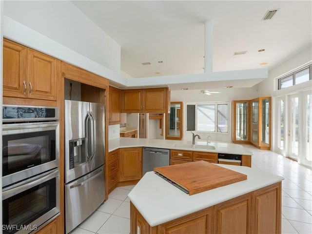 561 Conover Ct, Marco Island, FL 34145 - kitchen with stainless steel appliances, a sink, light tile patterned floors, and light countertops