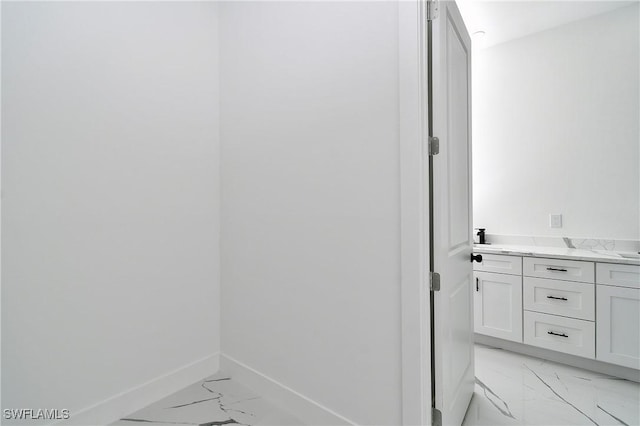 317 Lancelot Ave, Lehigh Acres, FL 33974 - bathroom featuring marble look tile flooring, baseboards, and double vanity