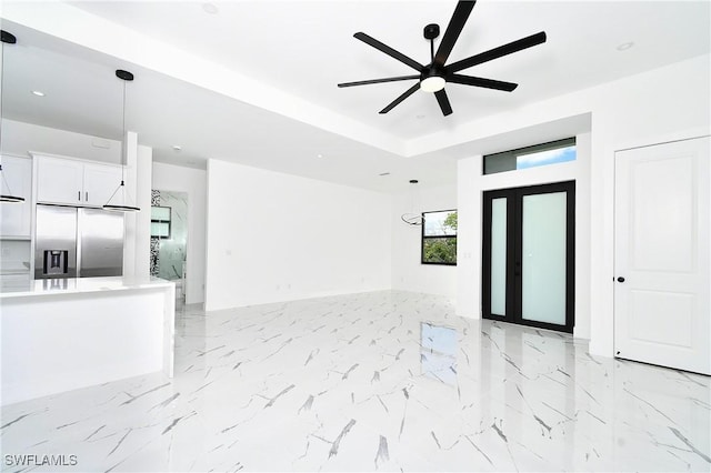 317 Lancelot Ave, Lehigh Acres, FL 33974 - unfurnished living room featuring ceiling fan, light marble finish floors, and a raised ceiling