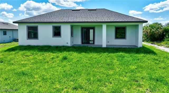 317 Lancelot Ave, Lehigh Acres, FL 33974 - rear view of property with a shingled roof, a yard, and stucco siding