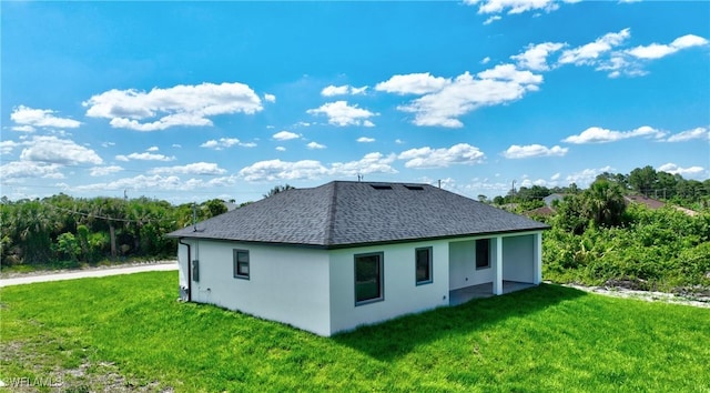 317 Lancelot Ave, Lehigh Acres, FL 33974 - back of property with a lawn, roof with shingles, and stucco siding