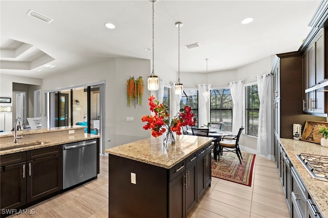 4382 Caldera Cir, Naples, FL 34119 - kitchen with stainless steel appliances, a sink, a kitchen island, decorative light fixtures, and light stone countertops