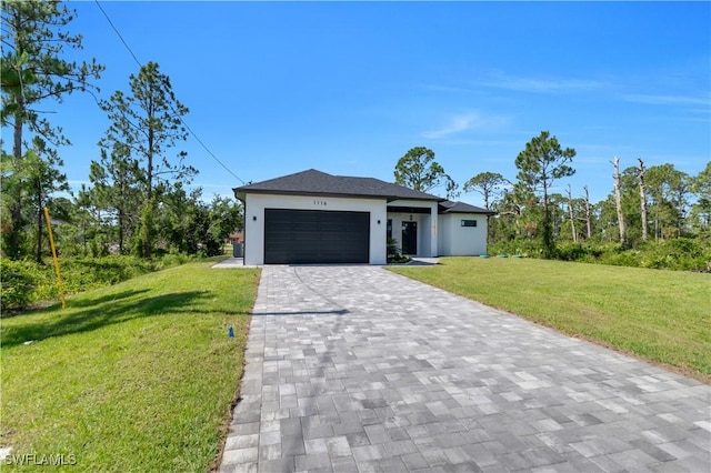 1116 Nimitz Blvd, Lehigh Acres, FL 33974 - view of front of property with decorative driveway, a garage, a front yard, and stucco siding