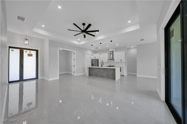 1116 Nimitz Blvd, Lehigh Acres, FL 33974 - unfurnished living room featuring a tray ceiling, baseboards, french doors, a ceiling fan, and recessed lighting