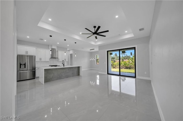 1116 Nimitz Blvd, Lehigh Acres, FL 33974 - unfurnished living room featuring a tray ceiling, recessed lighting, ceiling fan, baseboards, and a sink