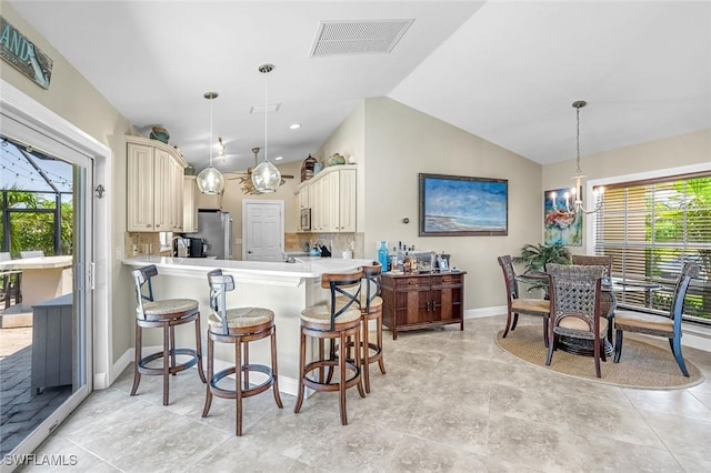 815 Rose Ct, Marco Island, FL 34145 - kitchen with freestanding refrigerator, cream cabinets, plenty of natural light, light countertops, and lofted ceiling