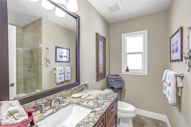 815 Rose Ct, Marco Island, FL 34145 - full bathroom featuring toilet, vanity, a tile shower, baseboards, and tile patterned floors
