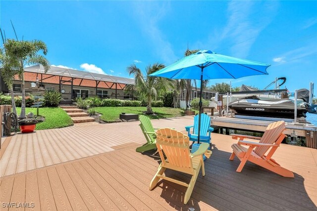 815 Rose Ct, Marco Island, FL 34145 - wooden terrace with boat lift, a dock, glass enclosure, and a yard