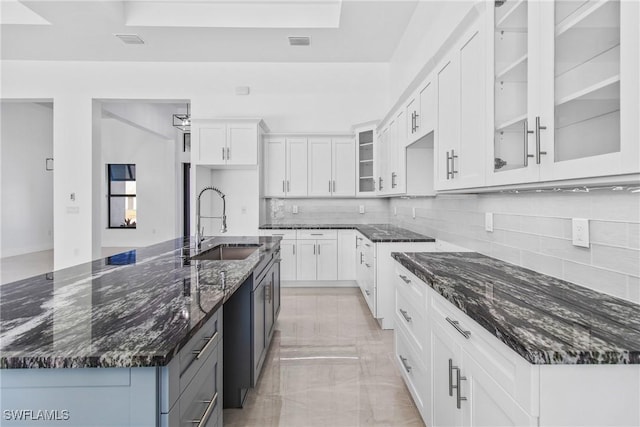 206 Jack Ave N, Lehigh Acres, FL 33971 - kitchen featuring a sink, decorative backsplash, white cabinets, and dark stone counters