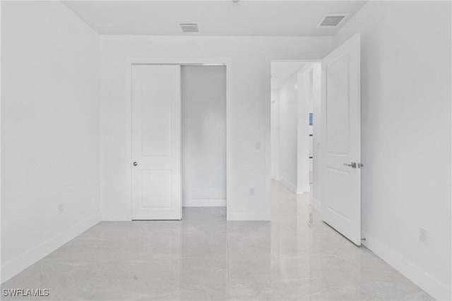 206 Jack Ave N, Lehigh Acres, FL 33971 - unfurnished bedroom with baseboards, a closet, and light marble finish flooring