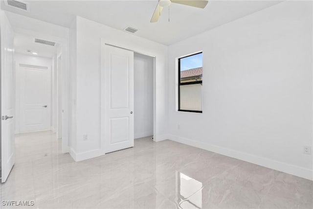 206 Jack Ave N, Lehigh Acres, FL 33971 - unfurnished bedroom with baseboards, light marble finish floors, a closet, and a ceiling fan