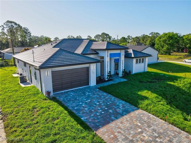 206 Jack Ave N, Lehigh Acres, FL 33971 - ranch-style home featuring a front yard, a garage, cooling unit, decorative driveway, and stucco siding