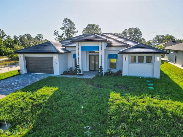 206 Jack Ave N, Lehigh Acres, FL 33971 - view of front of property featuring a garage, a front yard, french doors, and stucco siding