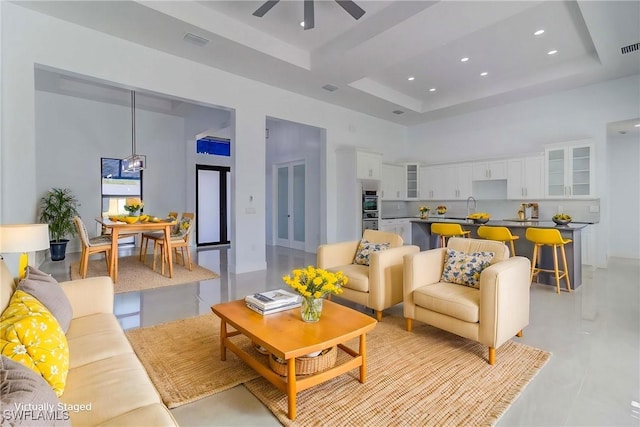 206 Jack Ave N, Lehigh Acres, FL 33971 - living room featuring a towering ceiling, ceiling fan, a tray ceiling, recessed lighting, and finished concrete floors