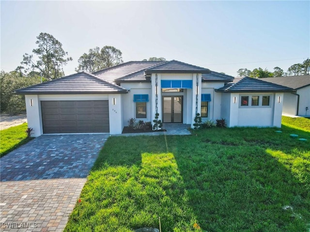 206 Jack Ave N, Lehigh Acres, FL 33971 - view of front of house featuring a front lawn, a garage, driveway, and french doors