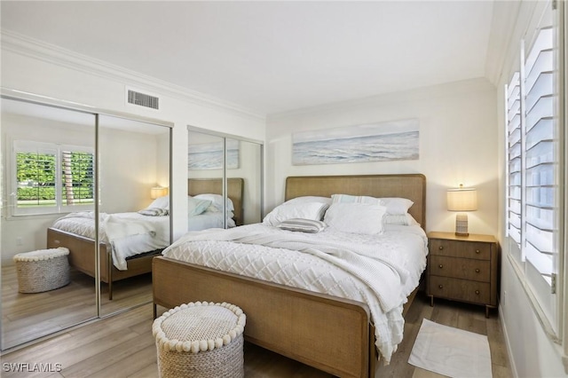 980 7th Ave S Unit 104, Naples, FL 34102 - bedroom featuring two closets, wood finished floors, and crown molding