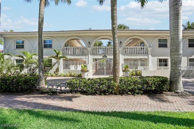 980 7th Ave S Unit 104, Naples, FL 34102 - back of house featuring stucco siding and a balcony