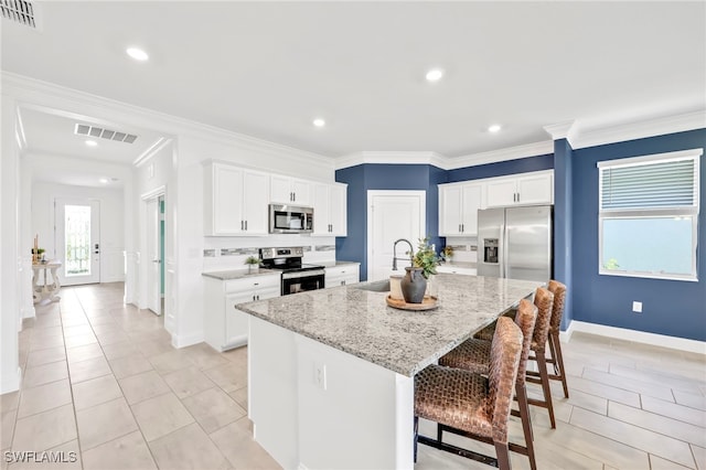 2127 Hamlin St, Naples, FL 34120 - kitchen featuring stainless steel appliances, a sink, a breakfast bar, baseboards, and a center island with sink