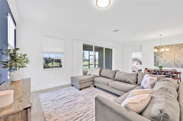 2127 Hamlin St, Naples, FL 34120 - living room featuring a chandelier, wood finished floors, and baseboards