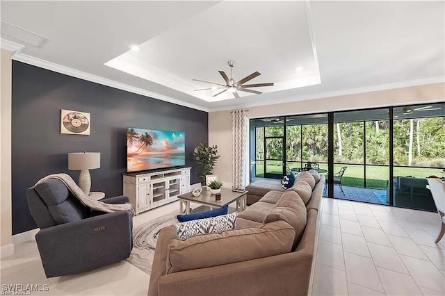 10367 Ventana Ln, Naples, FL 34120 - living room featuring a ceiling fan, a raised ceiling, ornamental molding, light tile patterned flooring, and baseboards