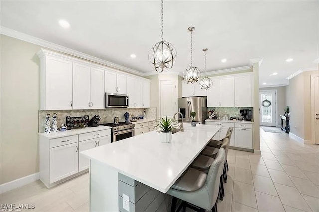 10367 Ventana Ln, Naples, FL 34120 - kitchen with stainless steel appliances, a center island with sink, tasteful backsplash, crown molding, and baseboards
