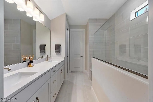 10367 Ventana Ln, Naples, FL 34120 - bathroom featuring a tile shower, double vanity, and baseboards