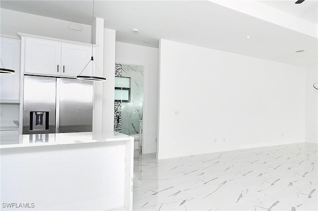 3808 2nd St W, Lehigh Acres, FL 33971 - kitchen with stainless steel refrigerator with ice dispenser, light marble finish flooring, white cabinets, and light countertops
