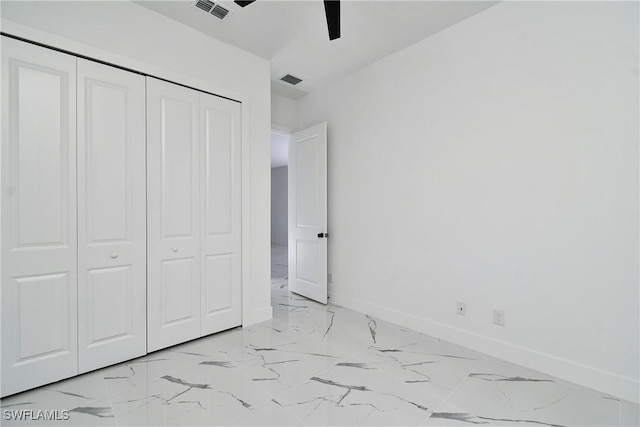 3808 2nd St W, Lehigh Acres, FL 33971 - unfurnished bedroom featuring light marble finish flooring, baseboards, a closet, and a ceiling fan