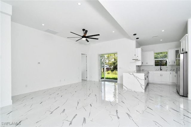 3808 2nd St W, Lehigh Acres, FL 33971 - unfurnished living room featuring a ceiling fan, recessed lighting, light marble finish flooring, and a sink