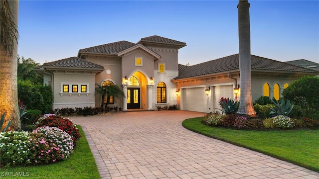 4249 Deephaven Ln, Naples, FL 34119 - mediterranean / spanish-style home featuring a garage, french doors, decorative driveway, stucco siding, and a tile roof