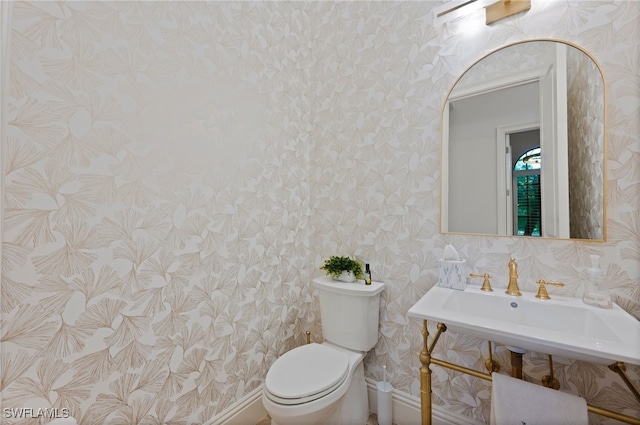 4249 Deephaven Ln, Naples, FL 34119 - bathroom featuring wallpapered walls, toilet, baseboards, and a sink